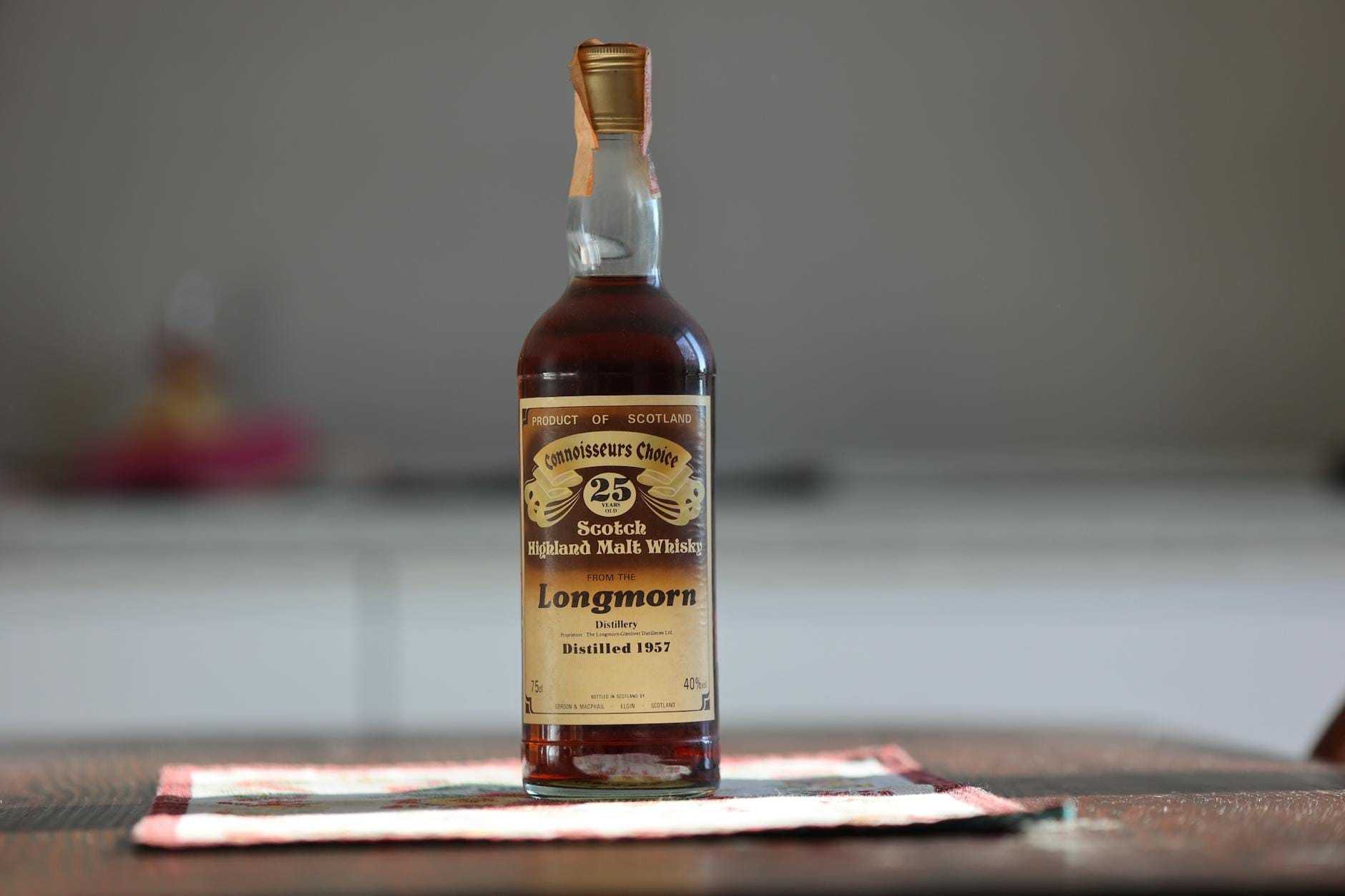 Butelka 25-letniej whisky Longmorn na tle drewnianego blatu