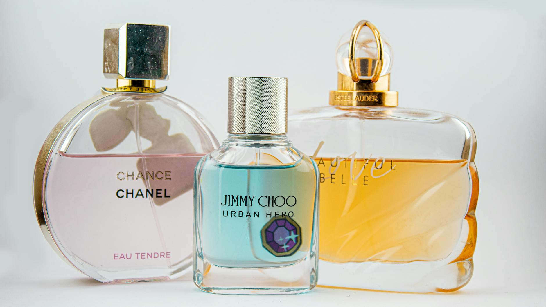 Flakony perfum Chanel, Jimmy Choo i Estee Lauder na eleganckiej półce