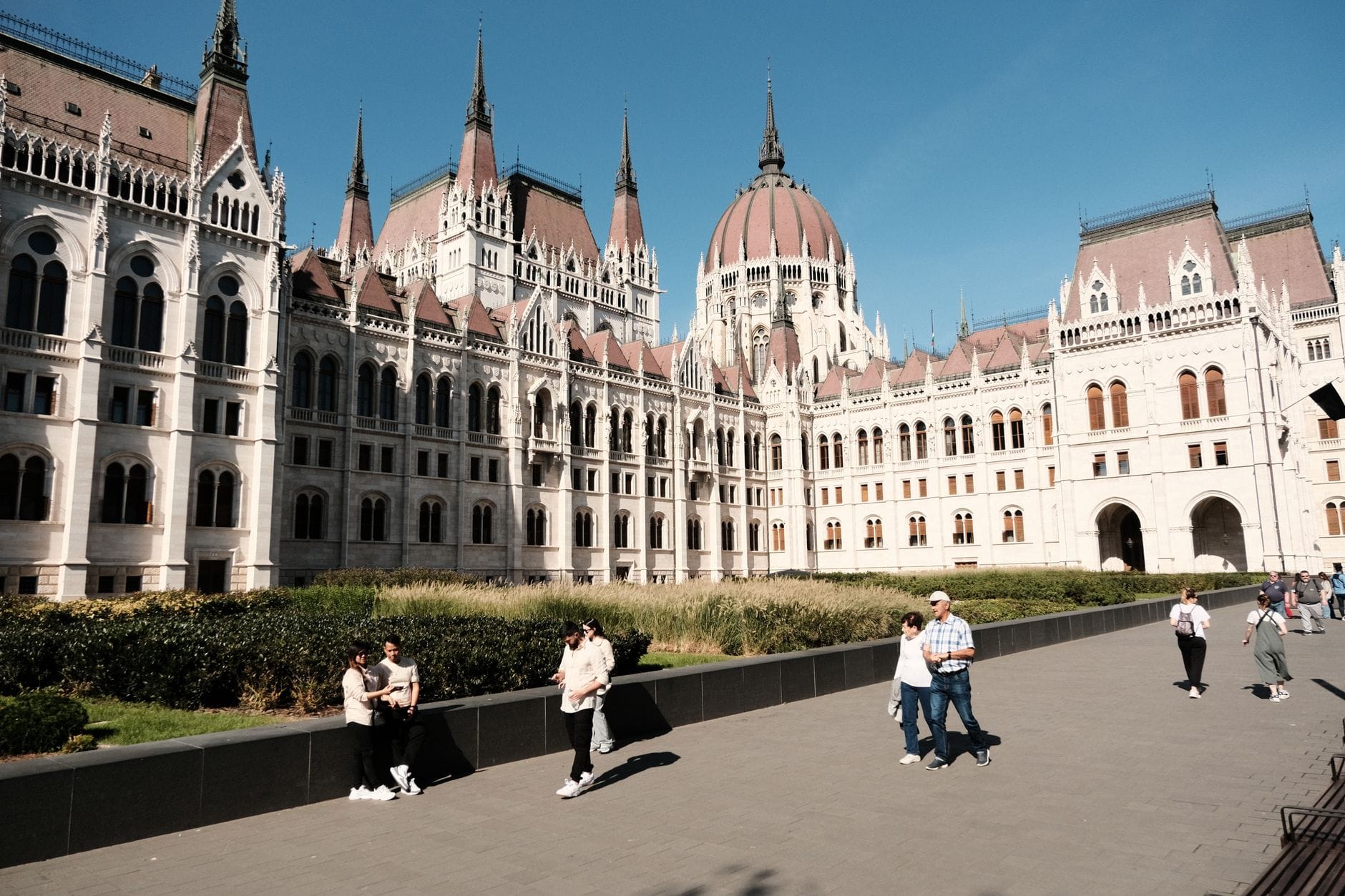 Budapeszteński Parlament nad Dunajem, ludzie spacerują w słoneczny dzień
