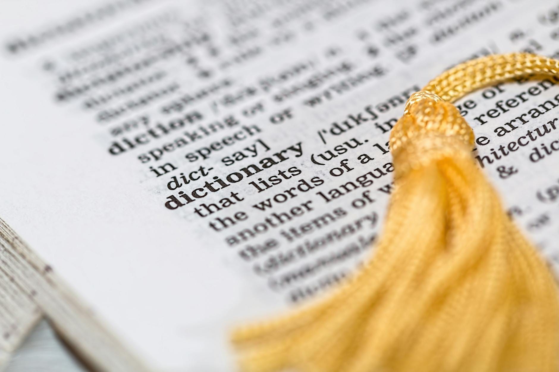 Strona słownika z wyrazem dictionary i żółtym frędzlem jako zakładką
