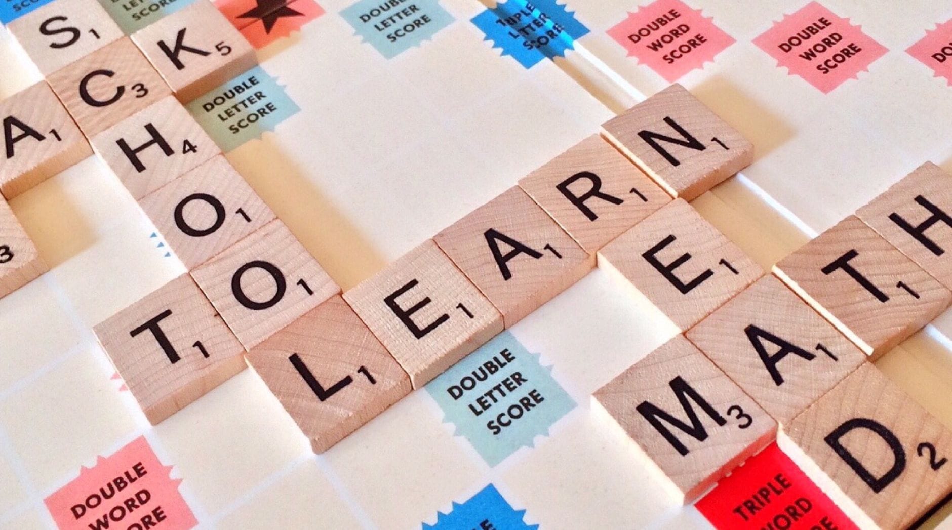 Zbliżenie na płytki Scrabble układające słowa o edukacji